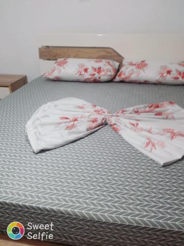 a bed with two towels with a bow on it at Guest House Kaludhi in Kaludh