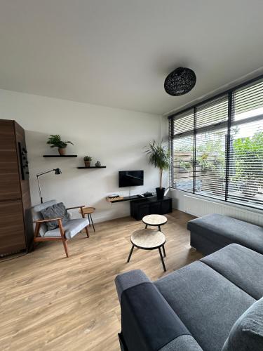 a living room with a couch and a table at De Schelp 86, Garden and Free parking in Zandvoort