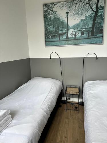 two beds in a room with a picture on the wall at De Schelp 86, Garden and Free parking in Zandvoort