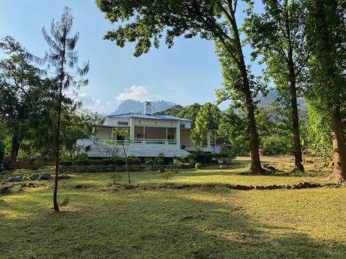 a house in the middle of a field with trees at Byounique House in Zomba