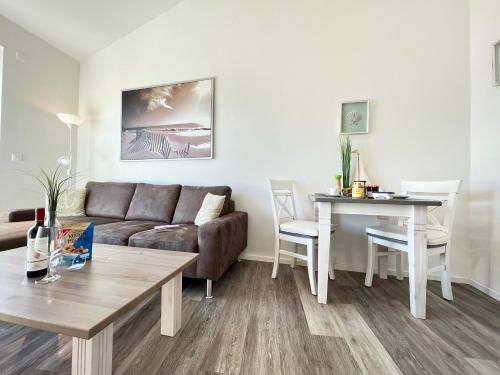 a living room with a couch and a table at ZUM LEUCHTTURM Wellness-Appartement APPARTO Grömitz in Grömitz