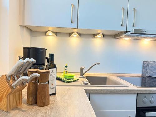 a kitchen counter with a sink and a bottle of wine at ZUM LEUCHTTURM Wellness-Appartement APPARTO Grömitz in Grömitz
