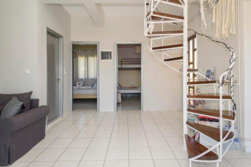 a spiral staircase in a living room with a couch at Navarino Golden sunset Apartment in Pylos