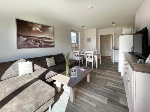 a living room with a couch and a table at ZUR STEILKÜSTE Wellness-Appartement APPARTO Grömitz in Grömitz