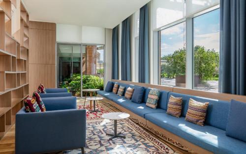 a lobby with blue couches and a large window at Lankaran Springs Wellness Resort in Lankaran