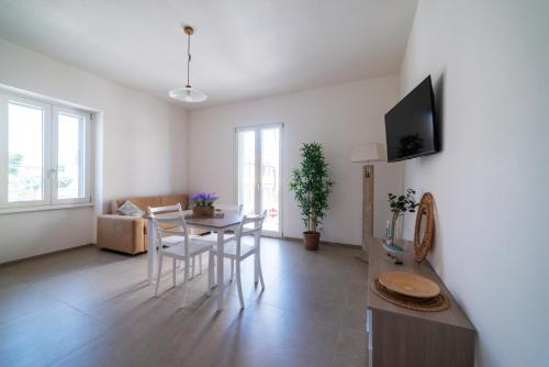 a living room with a table and chairs and a couch at Goccia Celeste - Gocce sul Mare in Savelletri di Fasano