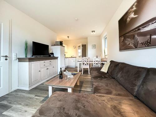 a living room with a couch and a table at ZUR STRANDPROMENADE Wellness-Appartement APPARTO Grömitz in Grömnitzerhagen