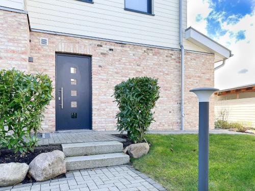 a brick house with a blue door and some rocks at ZUR STRANDPROMENADE Wellness-Appartement APPARTO Grömitz in Grömnitzerhagen