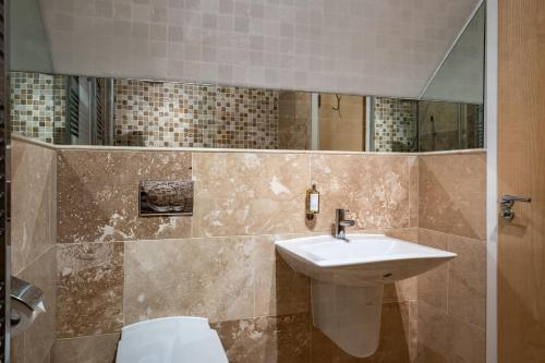 a bathroom with a sink and a mirror at Trewhiddle Retreat V27 by Together Travel - Luxury 3-Bedroom Villa in St Austell