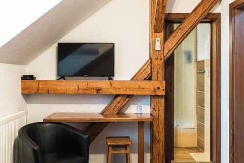 a living room with a desk with a tv and a chair at Penzión Pri Mlyne in Nitra