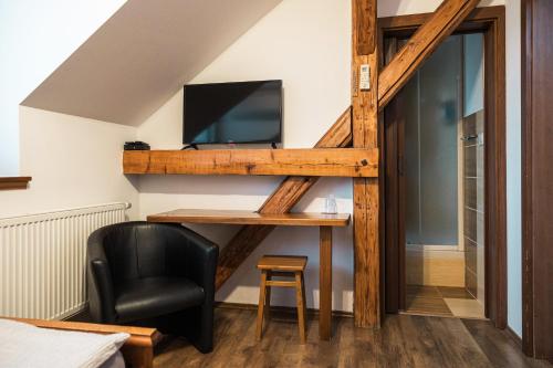 a room with a desk with a television and a chair at Penzión Pri Mlyne in Nitra