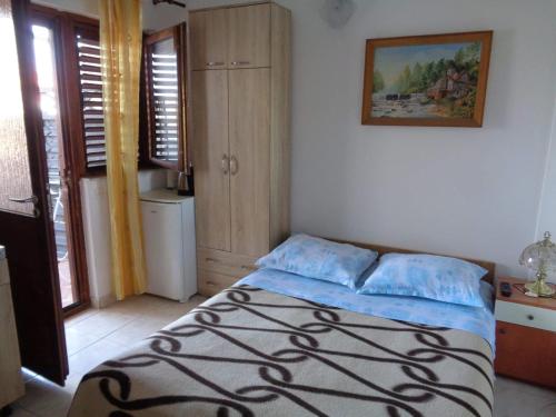 a bedroom with a bed in a room with windows at Apartment Tereza in Sukošan