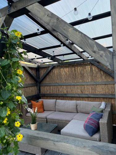 a patio with a couch and a table at Piejūras Namiņš in Ragaciems