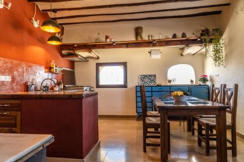 a kitchen and dining room with a table and chairs at Cortijo Los Llanos in Huéscar