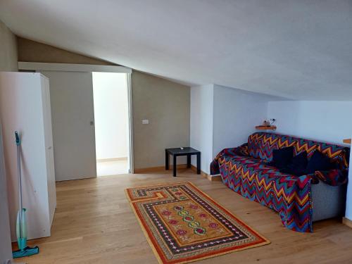 a living room with a couch and a rug at Mandulivi, chalet nel mandorleto e mansarda vista mare in Villaggio Azzurro
