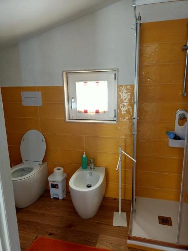 a bathroom with a toilet and a sink and a tub at Mandulivi, chalet nel mandorleto e mansarda vista mare in Villaggio Azzurro