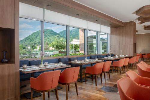 a restaurant with tables and chairs with mountains in the background at Lankaran Springs Wellness Resort in Lankaran