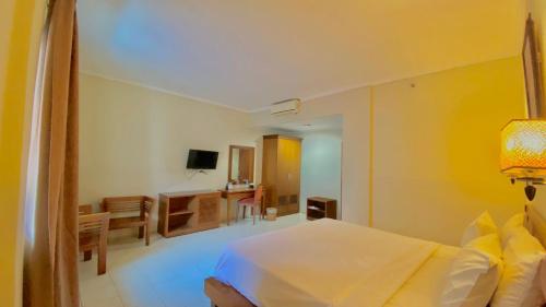 a bedroom with a bed and a living room at Pia Hotel in Cirebon