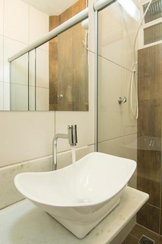 a white sink in a bathroom with a shower at Studio 202 in Petrópolis