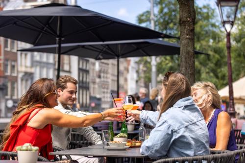 a group of people sitting at a table with drinks at Mister Highland Hotel in Amsterdam