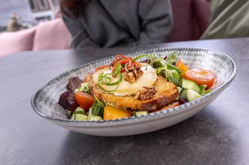 a bowl of salad with meat and vegetables on a table at Mister Highland Hotel in Amsterdam
