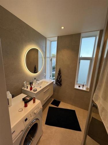 a bathroom with a washing machine and a sink at ONS Apartment in Stavanger