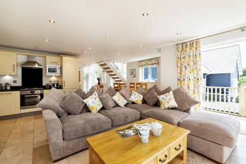 a living room with a couch and a table at Trewhiddle Retreat V27 by Together Travel - Luxury 3-Bedroom Villa in St Austell