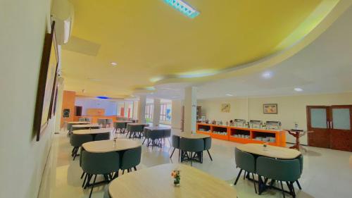 a restaurant with tables and chairs in a room at Pia Hotel in Cirebon