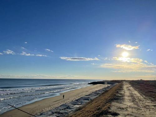 a view of a beach with the sun in the sky at The Utopia in Onjuku