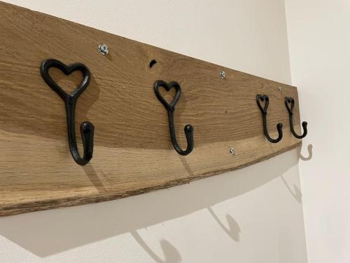 a wooden sign with two heart hooks on a wall at The old wash house in Denver