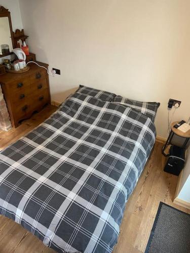 a bed with a black and white plaid comforter in a bedroom at The old wash house in Denver