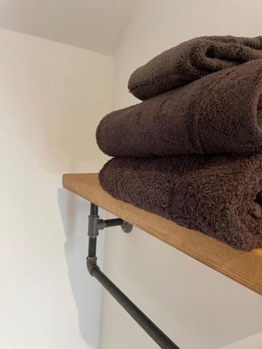 a pile of brown towels sitting on a wooden shelf at The old wash house in Denver