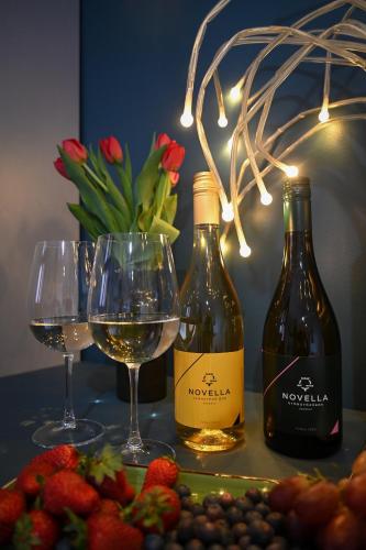 two bottles of wine and glasses on a table with strawberries at Bohém Borklub in Tállya