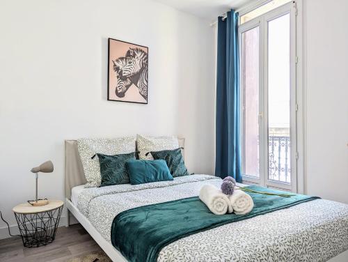 une chambre avec un lit avec deux serviettes dessus dans l'établissement L'escapade des poètes - central - baby-foot, à Béziers