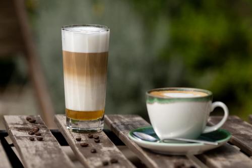 a drink and a cup of coffee on a wooden table at Bohém Borklub in Tállya