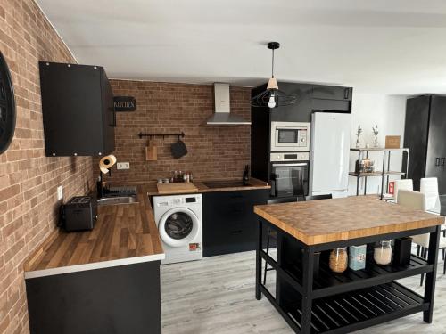 a kitchen with black appliances and a brick wall at Dream Factory Apartament in Tordesillas
