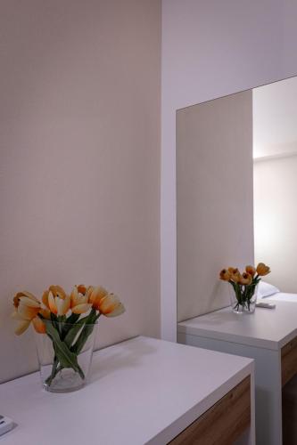 a vase of orange flowers on a counter in a room at Twins Hotel in Ksamil