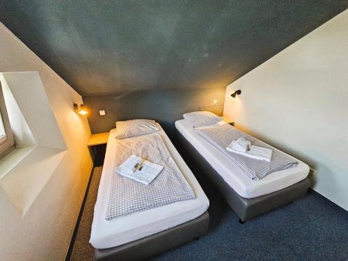 two beds sitting in a small room with lights at ARRIVEL Pension Pliening - bisher Novitel in Pliening