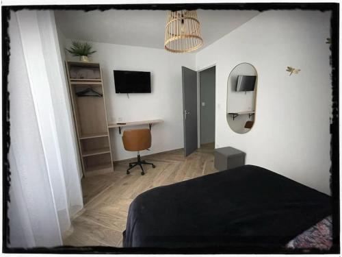 a bedroom with a bed and a desk with a computer at F2 Rez de Chaussée Ô meublé de Pithiviers in Pithiviers