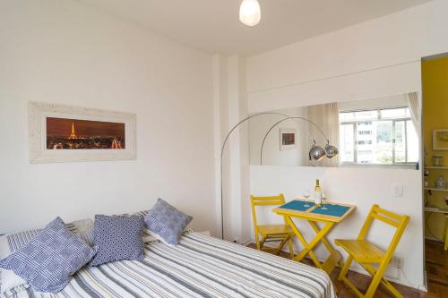 a bedroom with a bed and a table and chairs at Studio 704 in Petrópolis