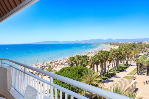 a balcony with a view of the beach and palm trees at UHC SANTILLANA FAMILY COMPLEX in Salou