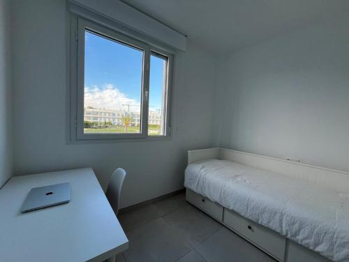 a white room with a bed and a window at Beach House Costa Ballena in Chipiona
