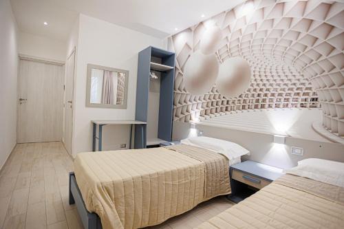 a room with two beds and a wall at Monia Rooms&Hospitality in Piazza Armerina