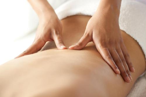 a woman massaging the back of a patient at 7 Rayons in Avignon