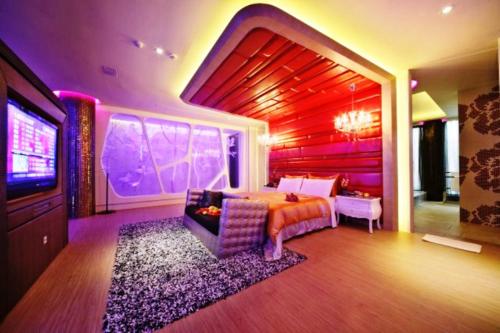 a bedroom with a bed and a tv in it at Han Guan Motel in Taichung