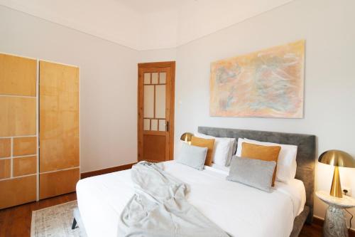 a bedroom with a white bed and a painting on the wall at Majestic Villa overlooking Acropolis with Hot Tub in Athens