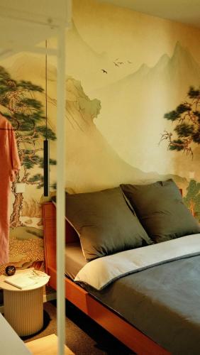 a bedroom with a bed with a painting on the wall at bluestar apartments am Storkower See inkl Badesteg und Gartensauna in Hubertushöhe