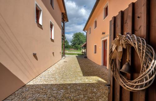 an alley between two buildings with a bell on the wall at Apartmány Pernek in Horní Planá
