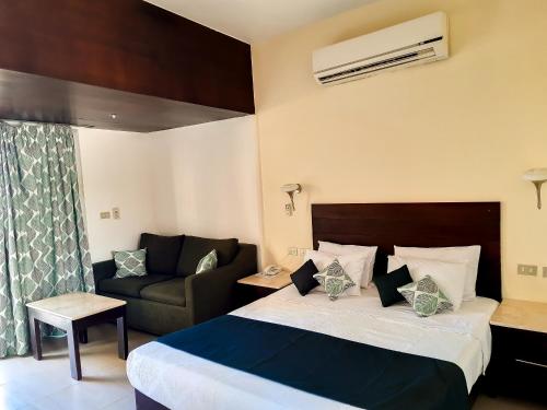 a hotel room with a bed and a couch at Beau Site Hotel in Marsa Matruh