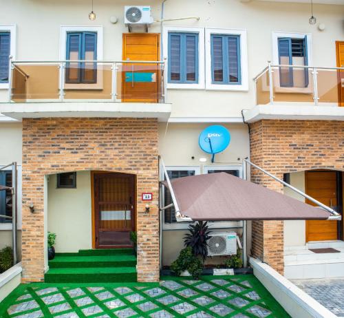 a house with a brown umbrella in front of it at Cozy 2Bed Terraced Duplex Apartment in Ajah-Lekki in Aja